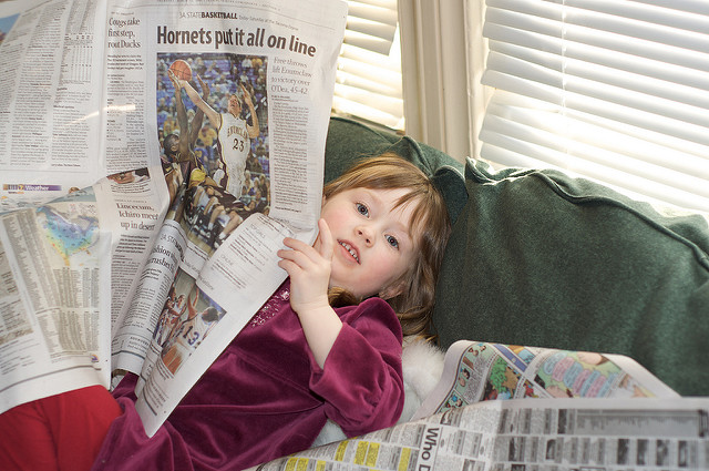 kid with newspaper reading 